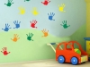 nursery children hand prints in colour on a wall with a toy in front of the wall