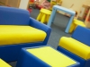 furniture inside a nursery of yellow and blue sofa, tables and stools