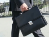 man walking with black briefcase in hand